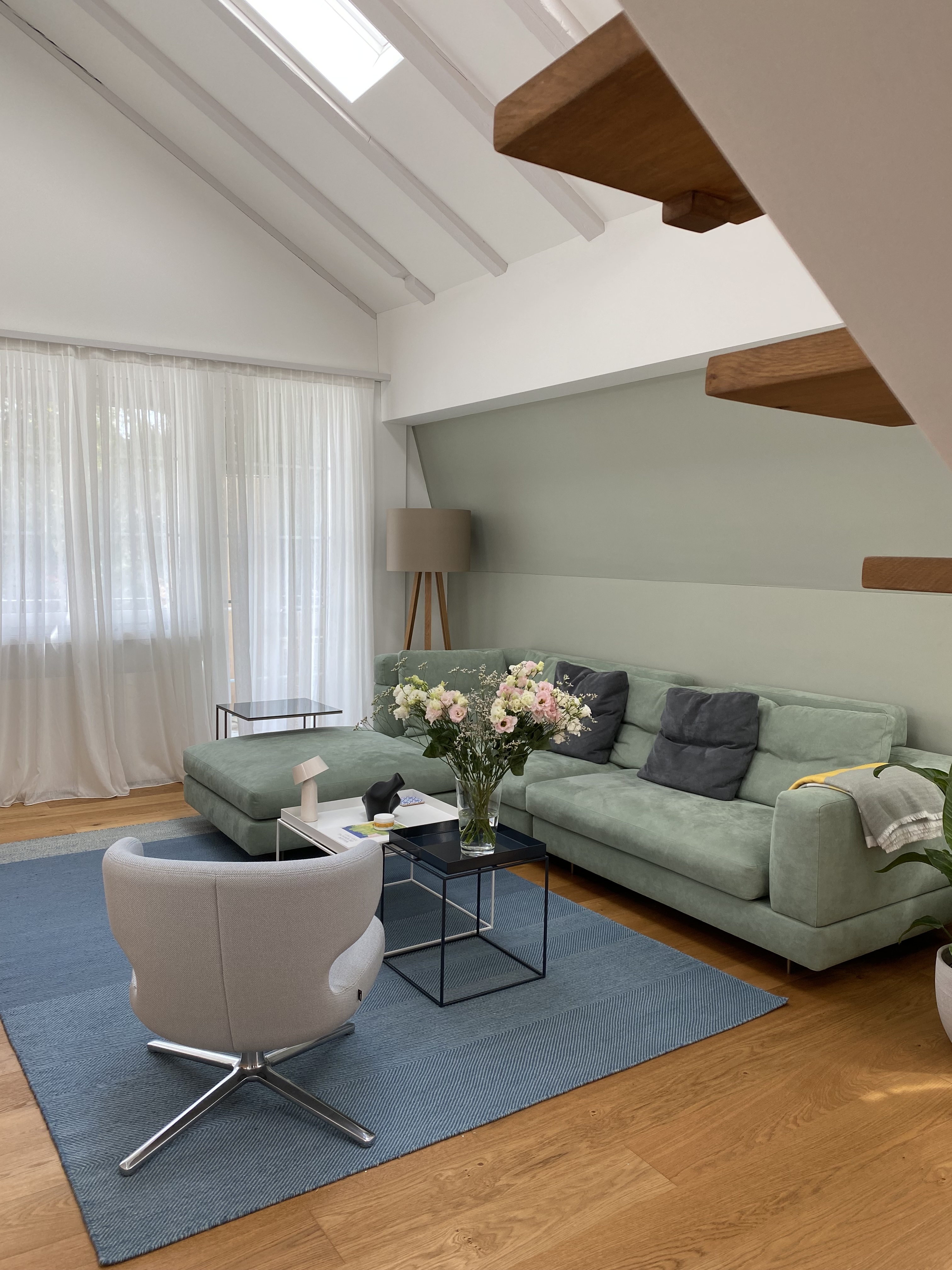 Farbig gestaltete Dachwohnung mit grüner Akzentwand und modernen Möbeln