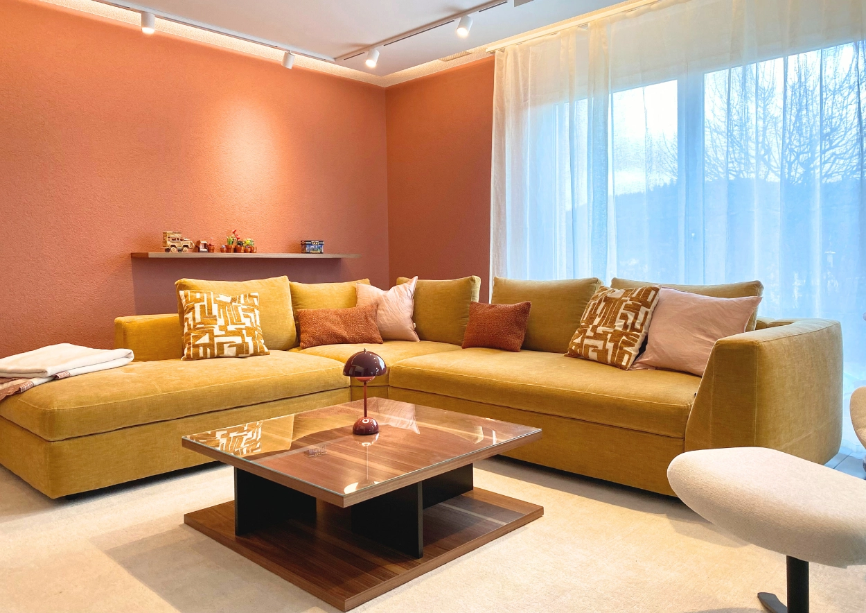 Gemütliches Wohnzimmer in warmen Erdtönen mit BoConcept Sofa und Designermöbeln