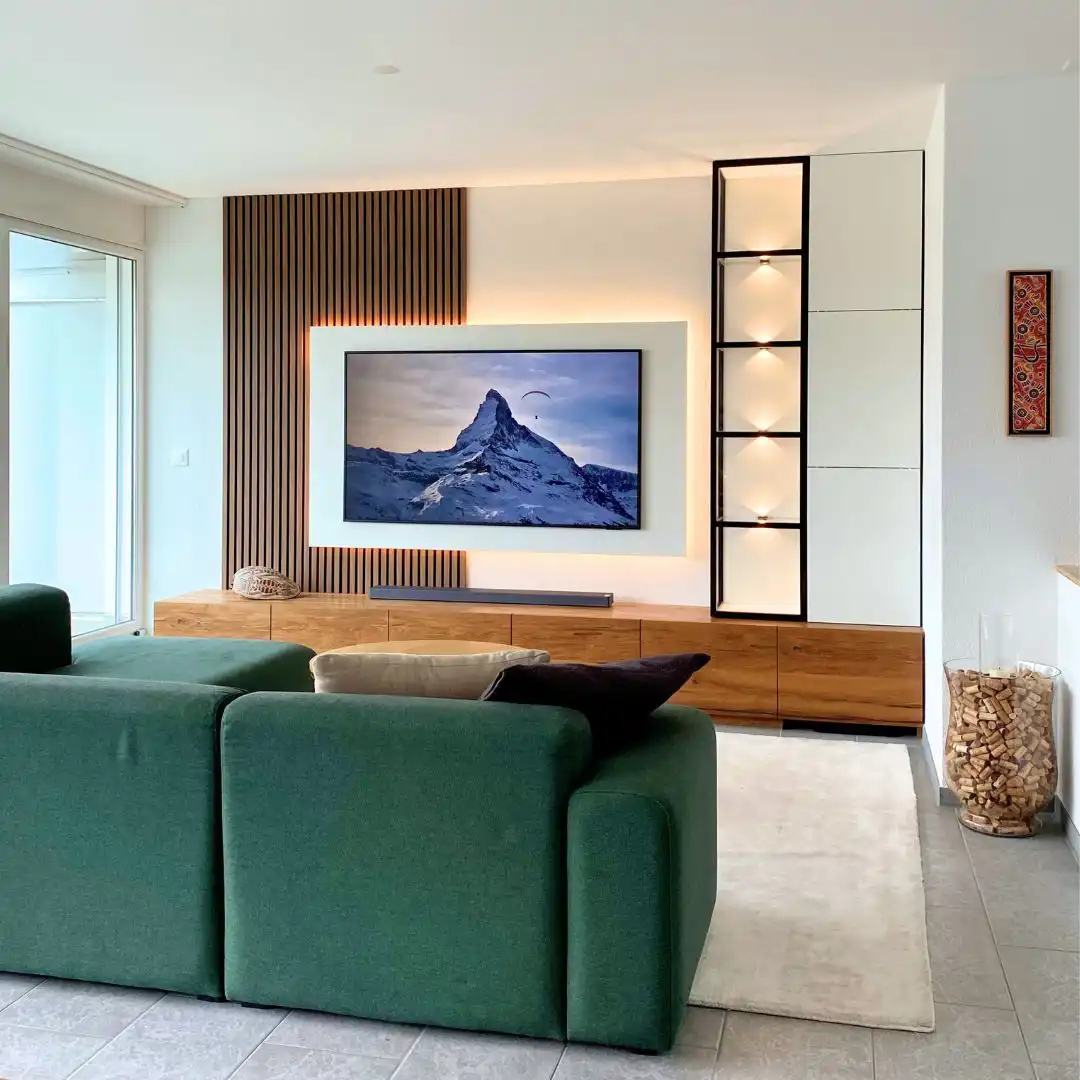 Wohnzimmer mit massgefertigter Wohnwand und grünem Sofa